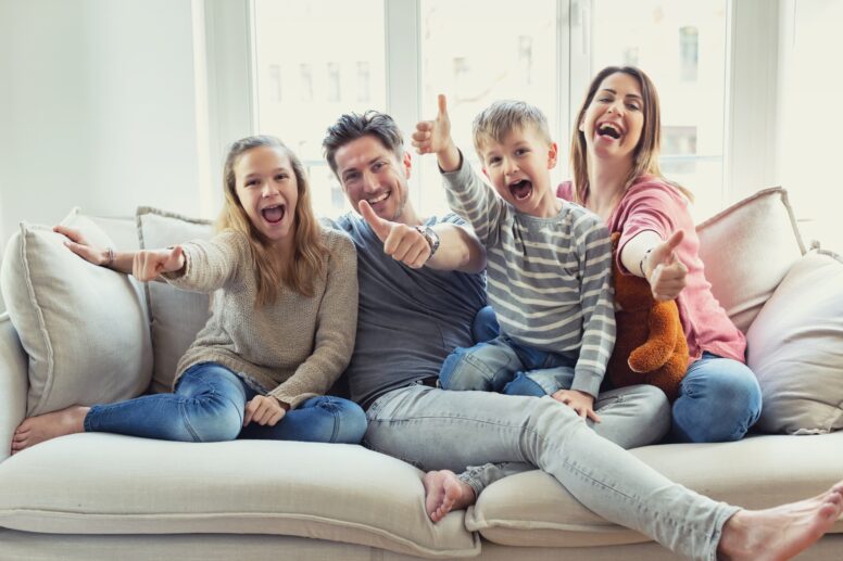Glückliche Familie lacht auf Sofa | Enthärtungsanlage